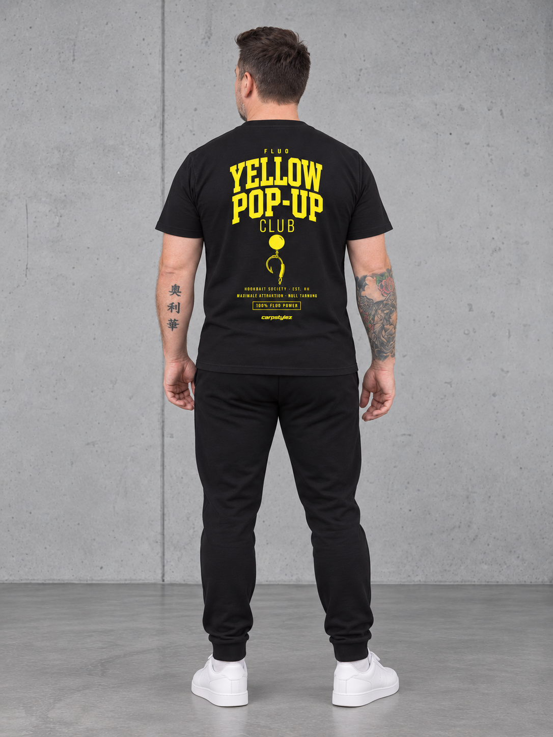 carpstylez Fluo Yellow Pop-Up Club – Olli trägt das schwarze Shirt, Ganzkörperansicht von hinten #farbe_black