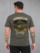 carpstylez GERMAN CARP SOCIETY Shirt – Olli trägt das khakifarbene Shirt mit Rückenprint #farbe_organic khaki