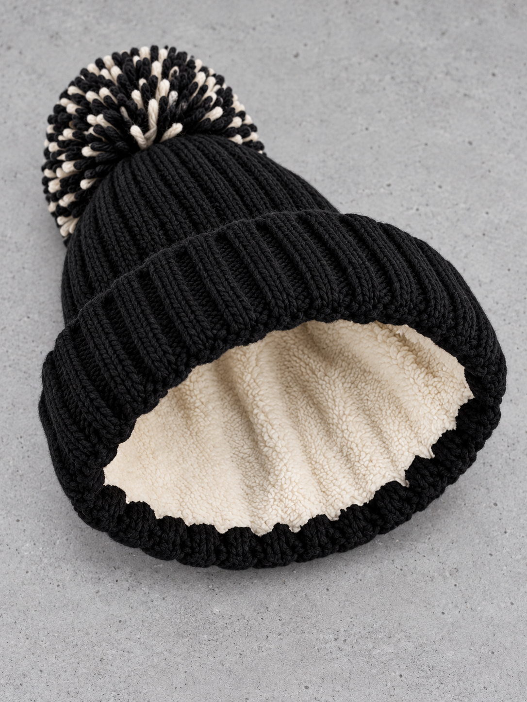 Sherpa Bommel Beanie Black – Detail des cremefarbenen Sherpa-Innenfutters #color_black, mustard