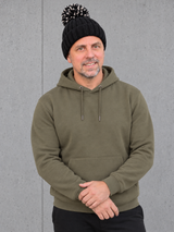 ESSENTIALS Sherpa Bommel Beanie in Black – Frontansicht, getragen von Olli mit Khaki-Hoodie #color_black