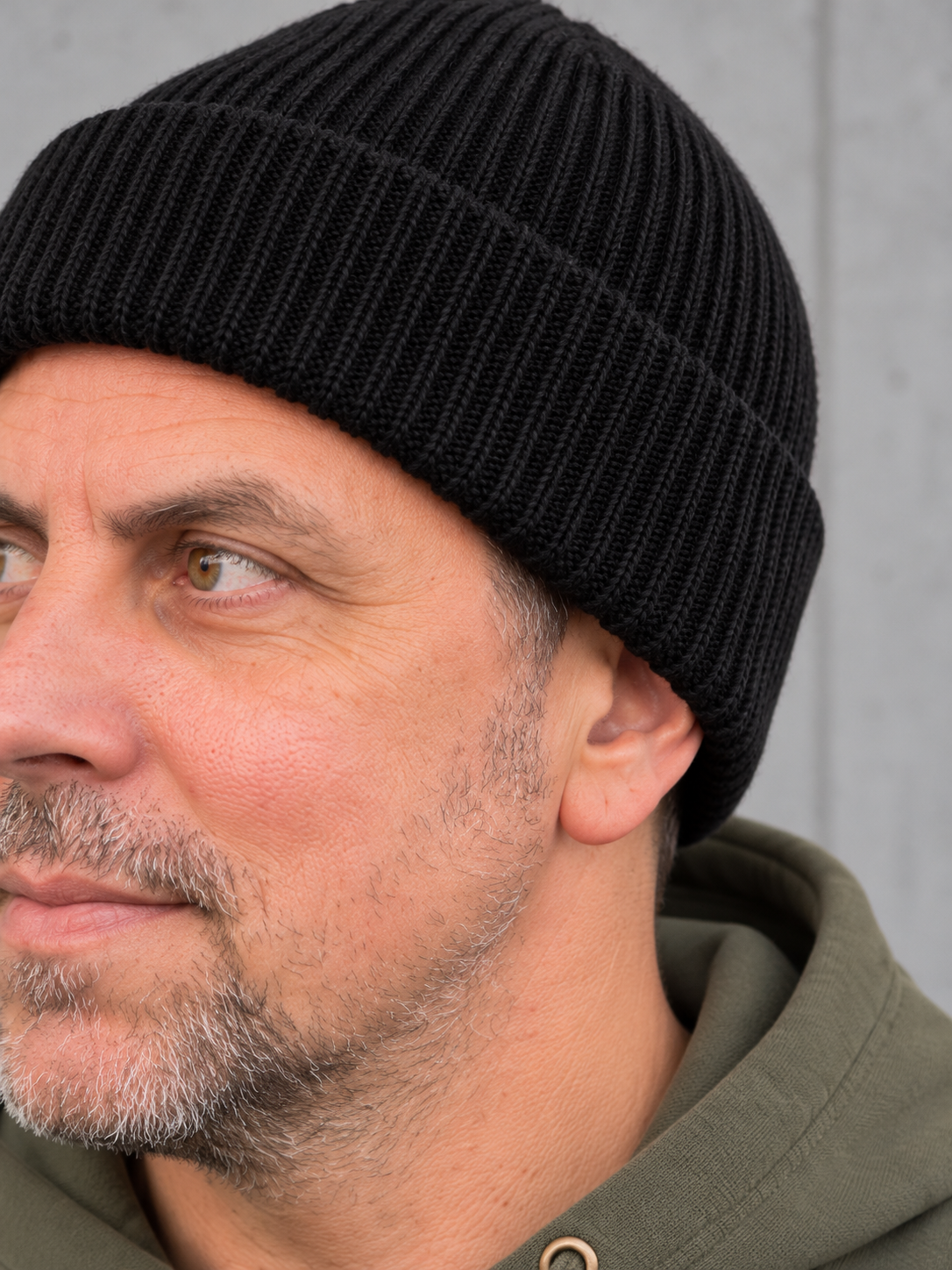 ESSENTIALS Wind Beanie in Black – Strickdetail, getragen von Olli mit Khaki-Hoodie #color_black, olive green, graphite grey