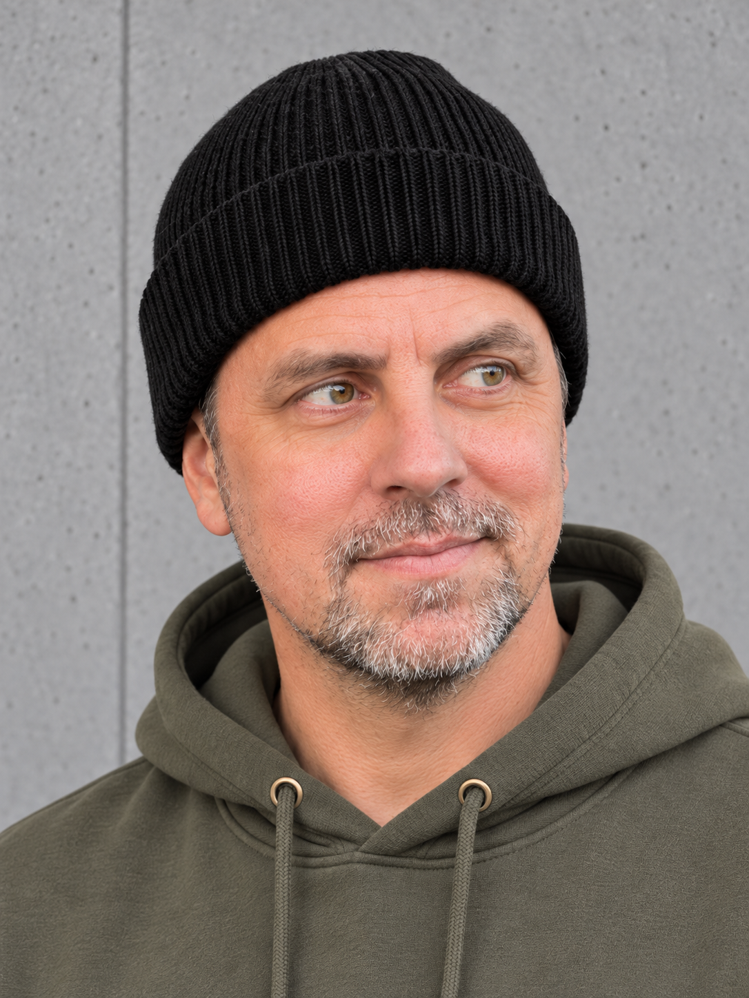 ESSENTIALS Wind Beanie Black – Mütze getragen von Olli, Kopf-Schulter-Nahaufnahme #color_black