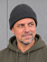 ESSENTIALS Wind Beanie Graphite Grey – Mütze getragen von Olli, Kopf-Schulter-Nahaufnahme #color_graphite grey