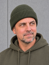 ESSENTIALS Wind Beanie Olive Green – Mütze getragen von Olli, Kopf-Schulter-Nahaufnahme #color_olive green