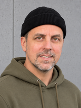 ESSENTIALS Fisherman Beanie Black – Mütze getragen von Olli, Kopf-Schulter-Nahaufnahme #color_black