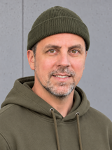 ESSENTIALS Fisherman Beanie Olive Green – Mütze getragen von Olli, Kopf-Schulter-Nahaufnahme #color_olive green