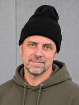 ESSENTIALS Long Beanie Black – Mütze getragen von Olli, Kopf-Schulter-Nahaufnahme #color_black