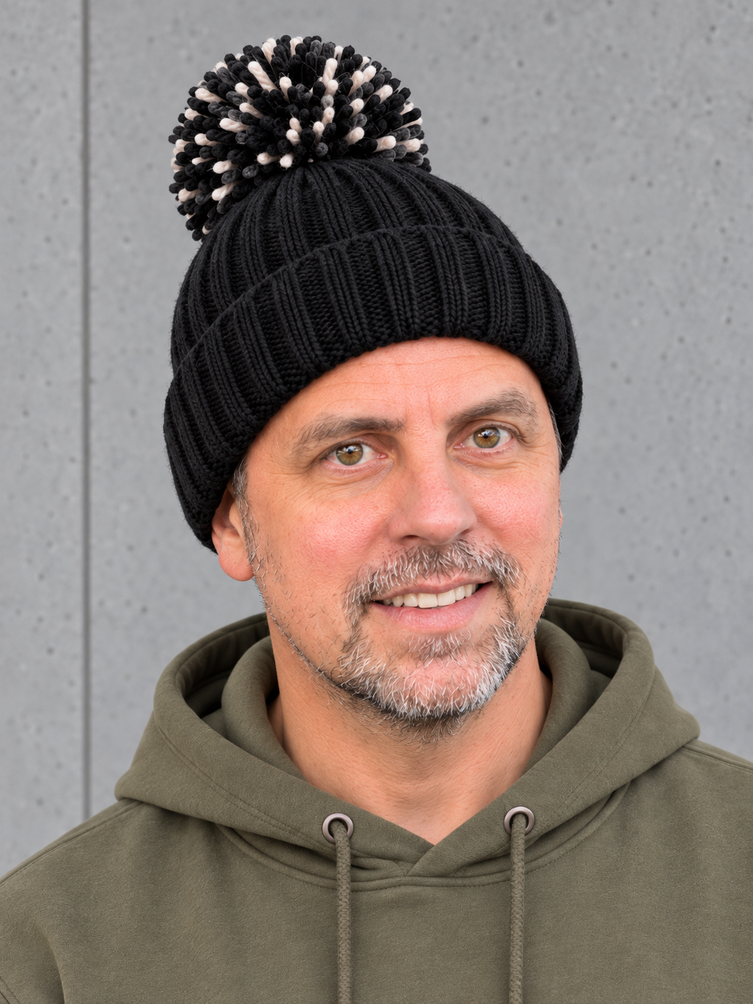 ESSENTIALS Sherpa Bommel Beanie Black – Mütze getragen von Olli, Kopf-Schulter-Nahaufnahme #color_black