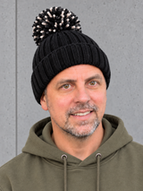 ESSENTIALS Sherpa Bommel Beanie Black – Mütze getragen von Olli, Kopf-Schulter-Nahaufnahme #color_black